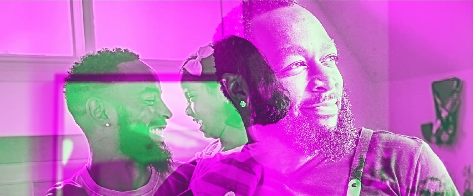 Man with a beard sits holding a young child on his lap while looking to the side. The same man appears again in a layered view smiling at the child.